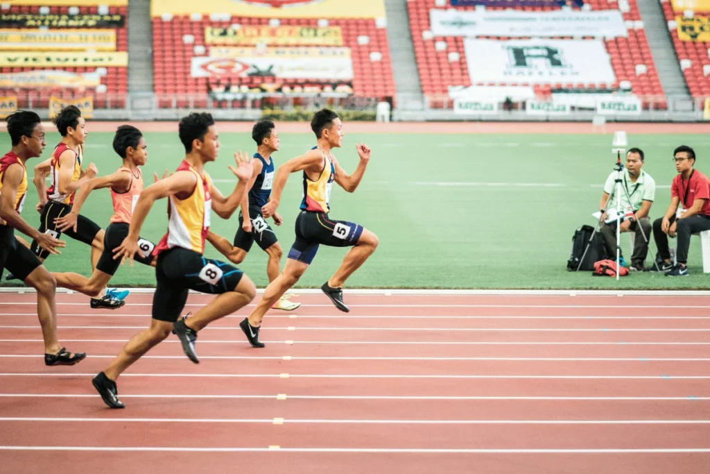 Athletes sprinting in a competitive track race at a stadium.