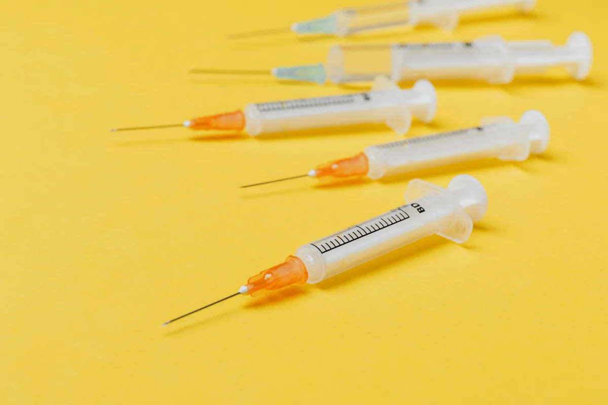 Medical syringes on a yellow background.