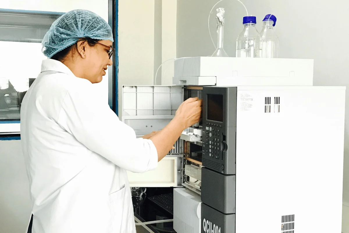 Laboratory technician operating a scientific machine for research.