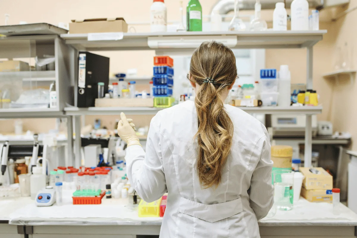 Researcher organizing equipment in a scientific laboratory setting.