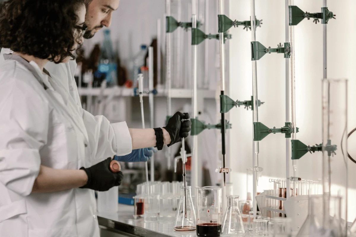 Two lab technicians working with scientific equipment in a research laboratory.