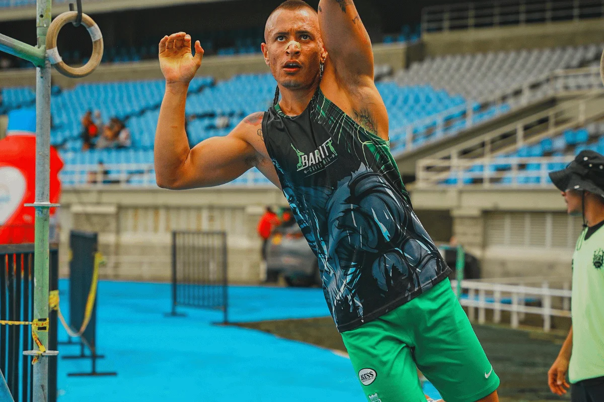 Athlete performing a ring exercise during an outdoor fitness competition.