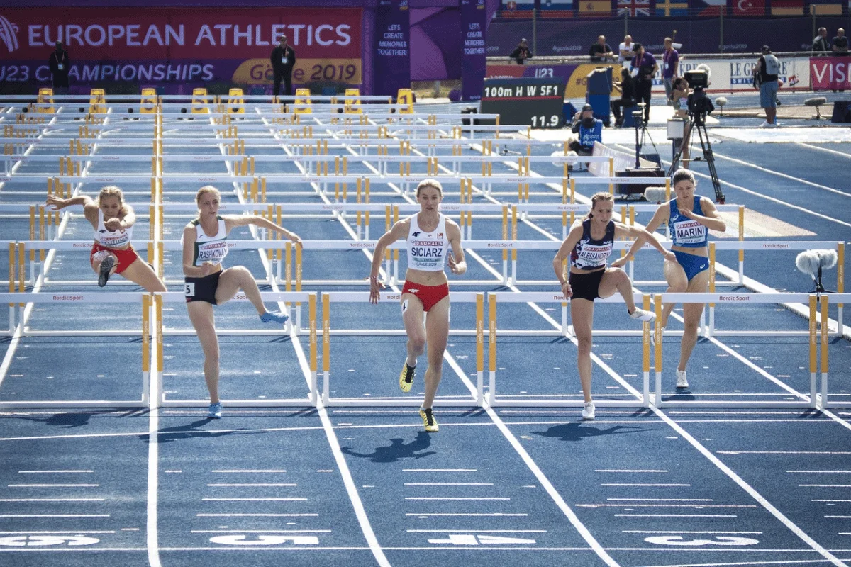 Female athletes competing in a 100m hurdles race at the European Athletics Championships.