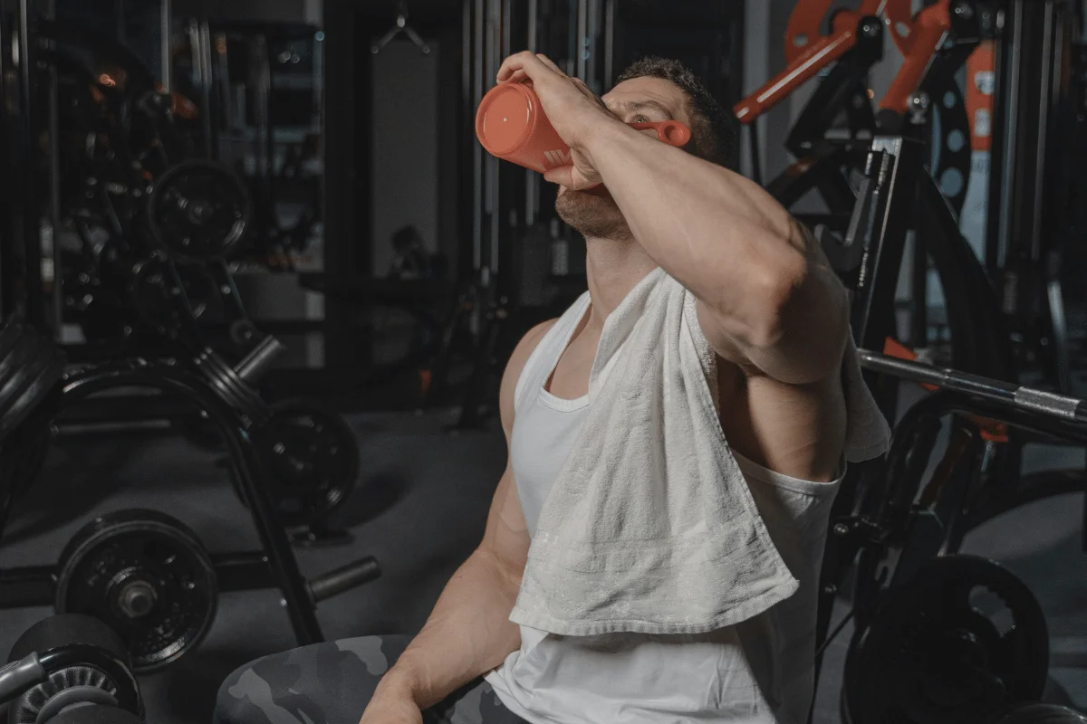 Person hydrating after a workout session in a fitness center.