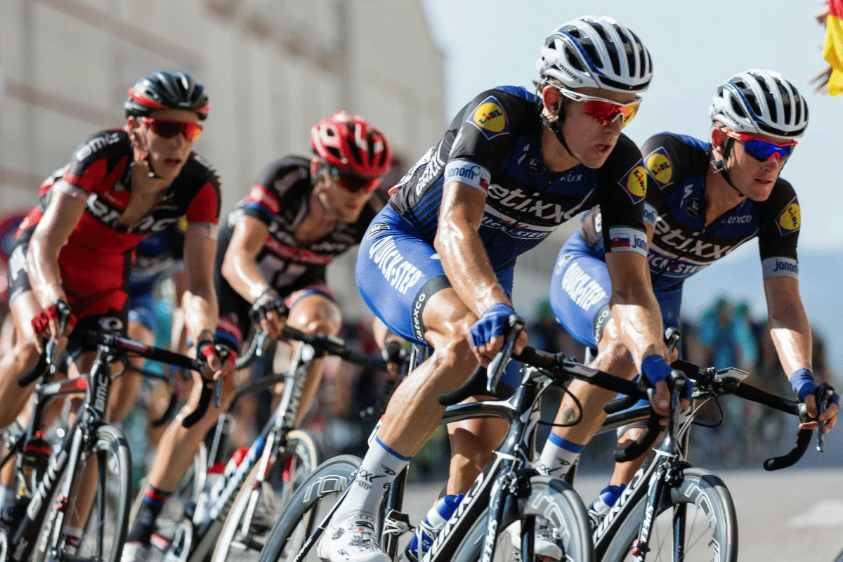 Group of professional cyclists racing in a competitive cycling event.