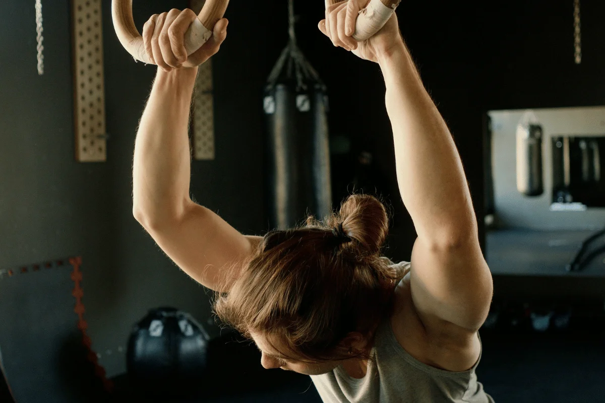 Close-up of a person using gymnastics rings during a workout.