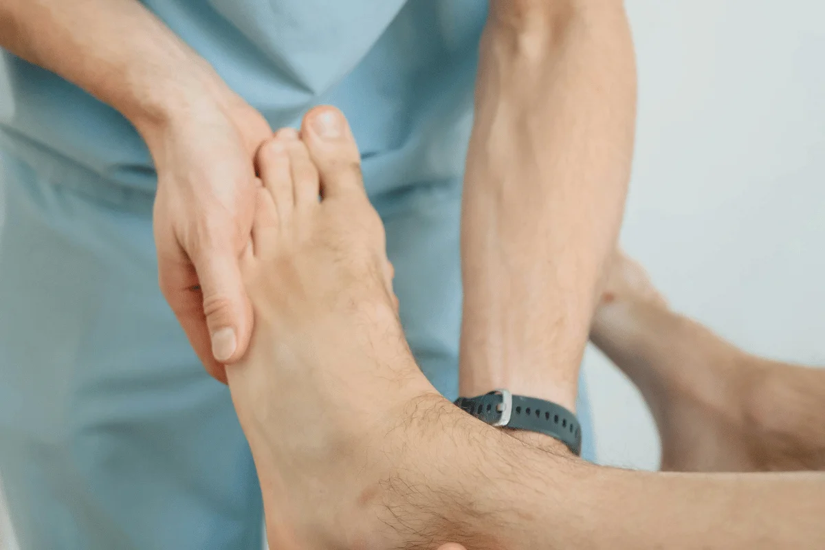 Healthcare provider examining a patient's foot during a physical check-up.