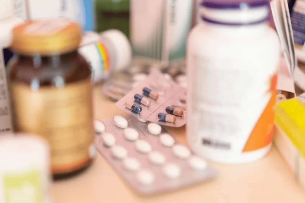 Close-up of various medication bottles and blister packs with capsules and tablets.