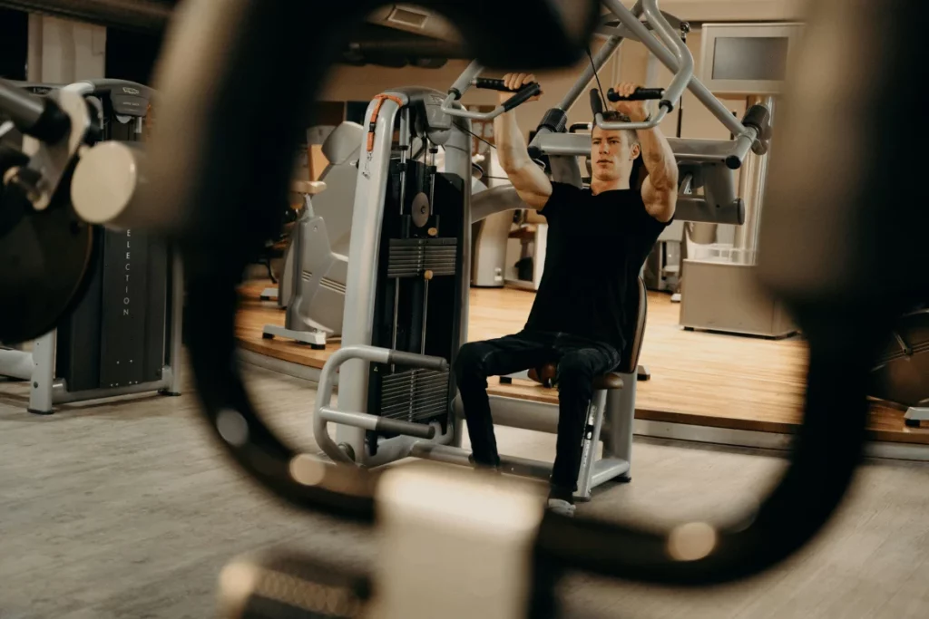 Man using a chest press machine at the gym for strength training.