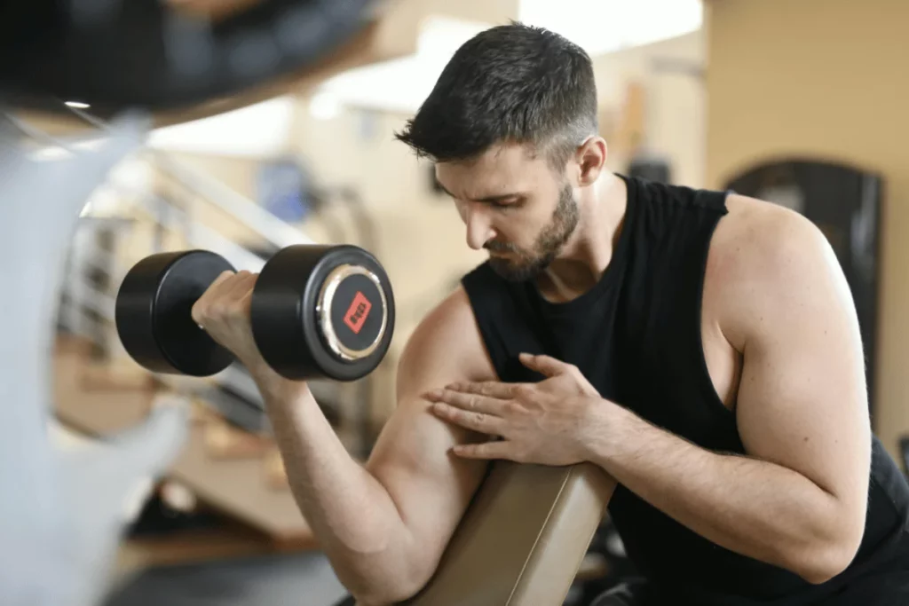 Focused weightlifter lifting a heavy dumbbell in a workout session.