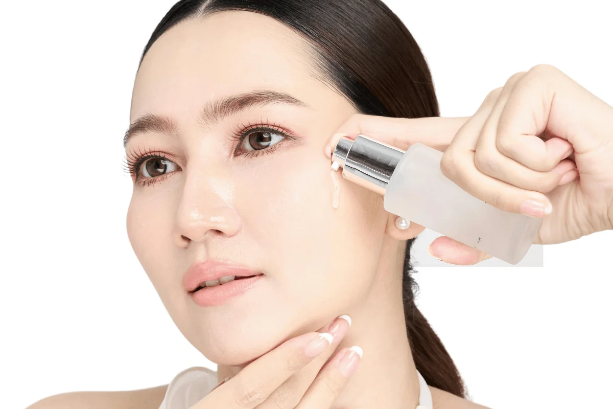 Woman applying a hydrating serum for glowing skin.