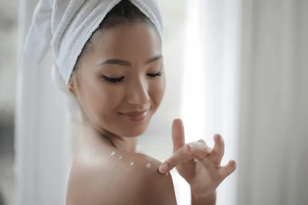 Fresh-faced woman in a towel enjoying a skincare moment.