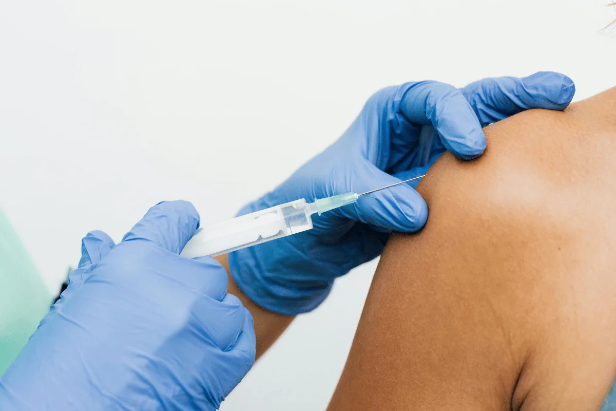 Healthcare professional administering an injection in the shoulder.