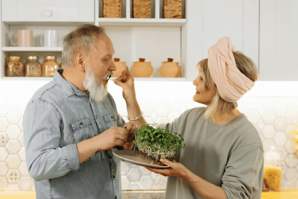 Happy senior couple enjoying fresh microgreens in a cozy kitchen.