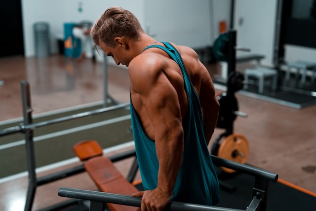 Lean gym goer doing dip movement