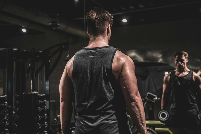 Man looking into the mirror at the gym.